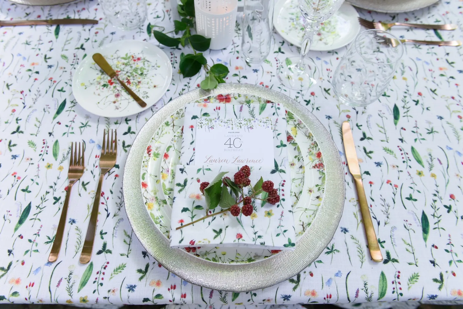 Coordinated botanical printed tablecloth and napkin with a floral place setting