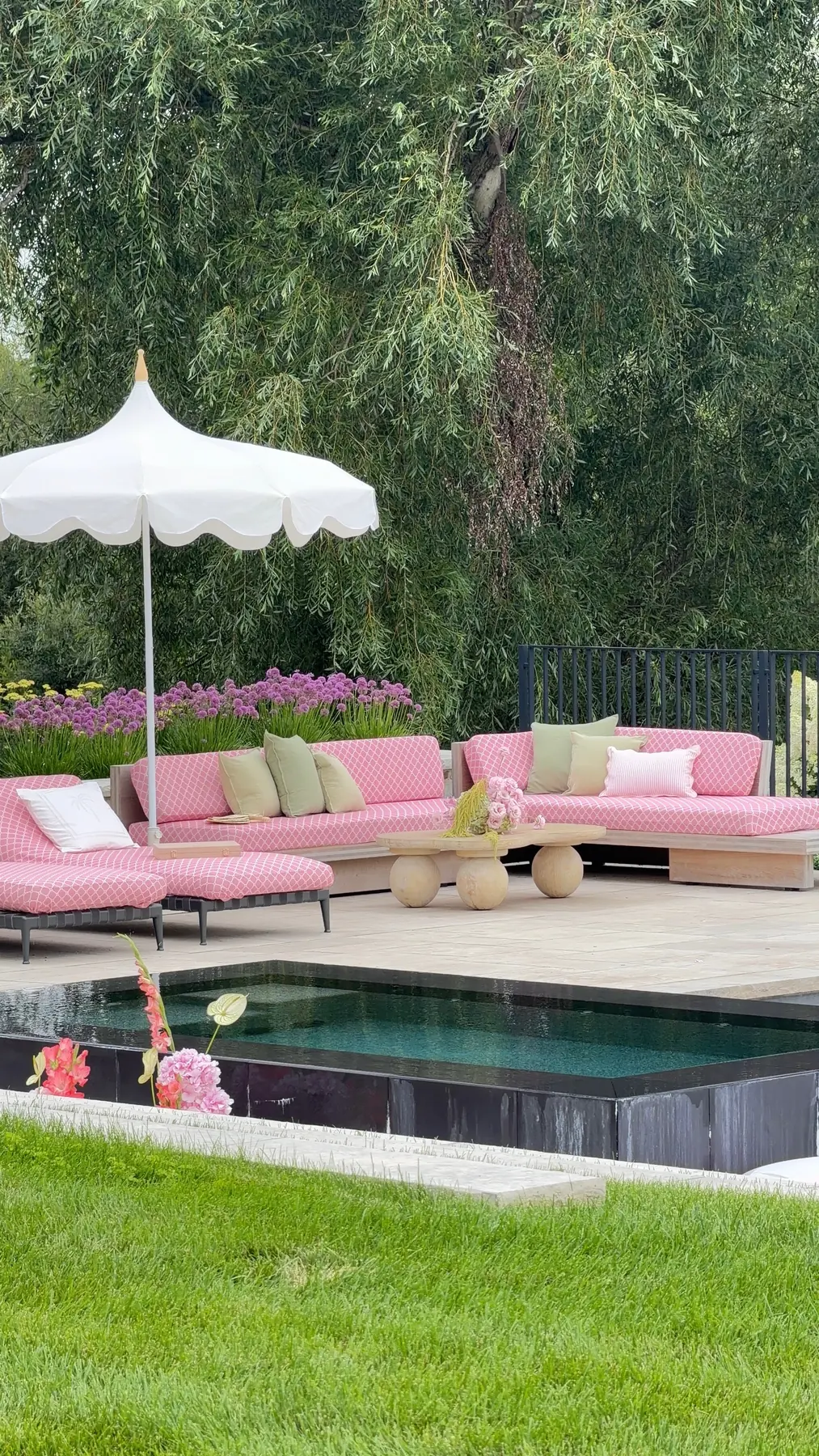 Poolside lounge seating upholstered in pink fabric with a white geometric printed pattern